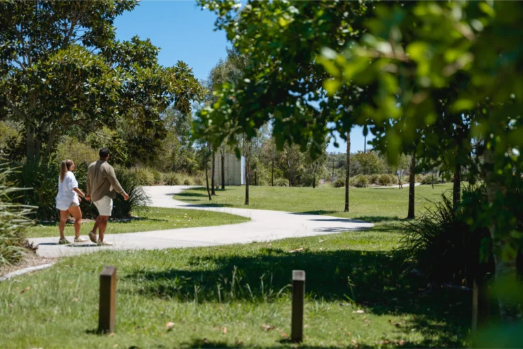 Couple walking hand in hand along a park path